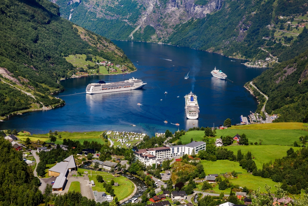 Pohled na lodě kotvicí u fjordu u městečka Geiranger, Norsko