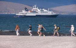 Celebrity Xpedition - Celebrity Cruises - stojící loď a procházející se lidé na ostrově