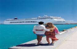 MSC Armonia - MSC Cruises - loď kotvící v azurově modrém moři s procházejícím párem