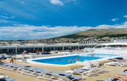 MSC Armonia - MSC Cruises - lidé v bazénu a v pozadí přístav