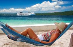 MSC Lirica - MSC Cruises - Žena relaxující v houpající síti a loď, kotvící v Karibiku 